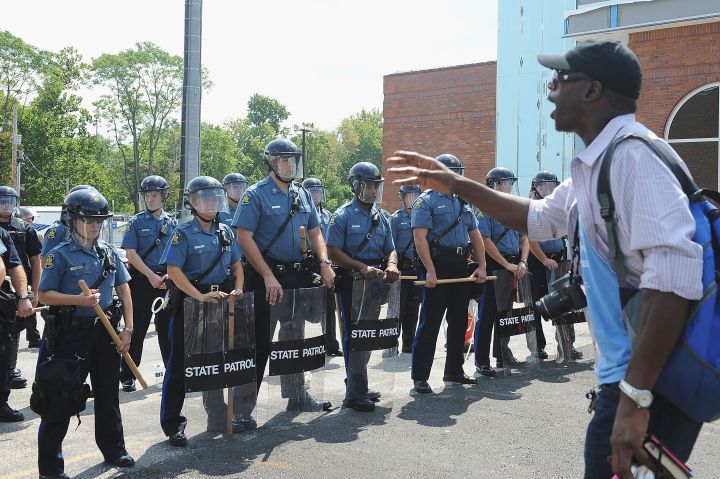A man protests as a wall of police hold tight in Ferguson.