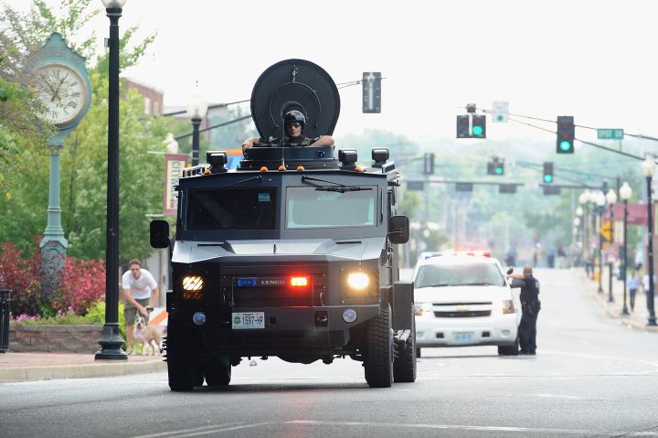 Police in a tactical vehicle travel down Ferguson streets to meet protestors.
