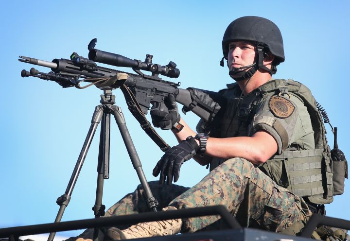 A sniper sits atop a vehicle in Ferguson.