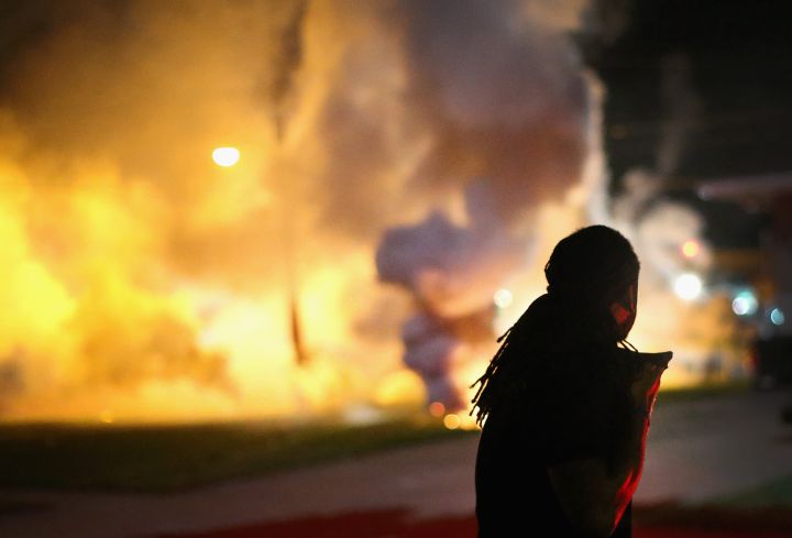 We lying? A resident of Ferguson watches as tear gas is released in the neighborhood.