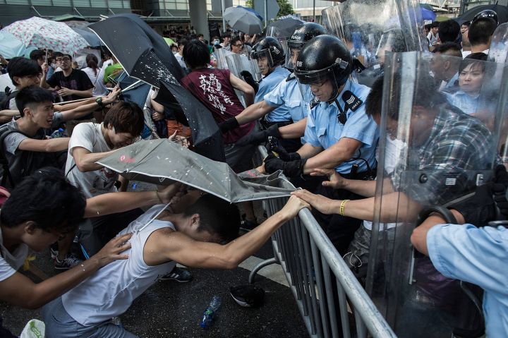 Police and demonstrators clash in the street during Hong Kong’s Umbrella Revolution, spurred by Chinese government’s plans to vet candidates in Hong Kong’s 2017 elections.