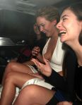 Jennifer Lawrence pops out of her dress while laughing in the car with singer Lorde.