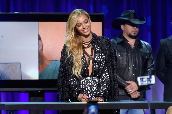 Beyonce shows off some pearly whites while signing the declaration.