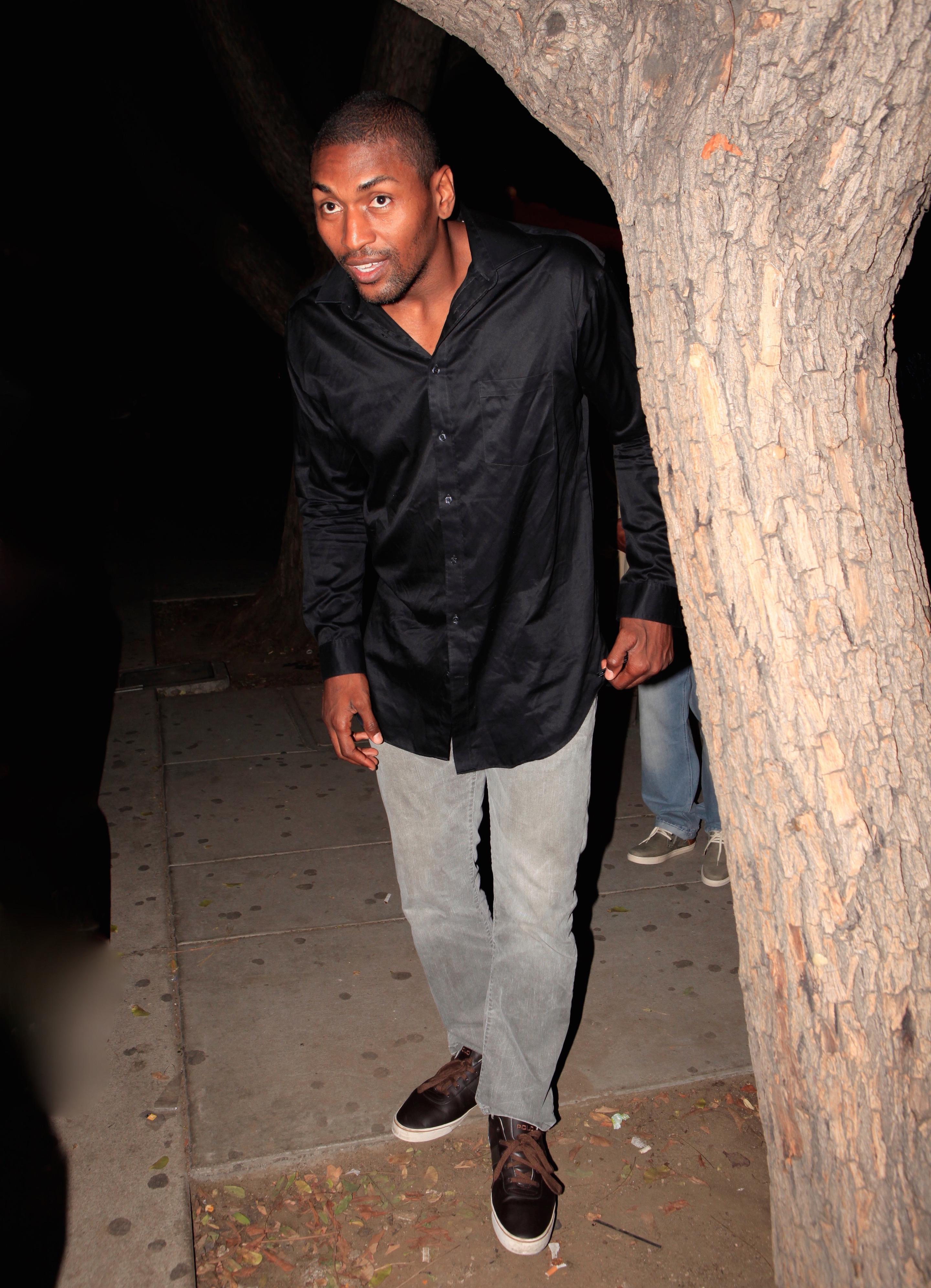 Nothing creepy about a 6 foot 7 inch professional basketball player named Metta World Peace standing behind a tree before heading into an L.A. nightclub with friends.