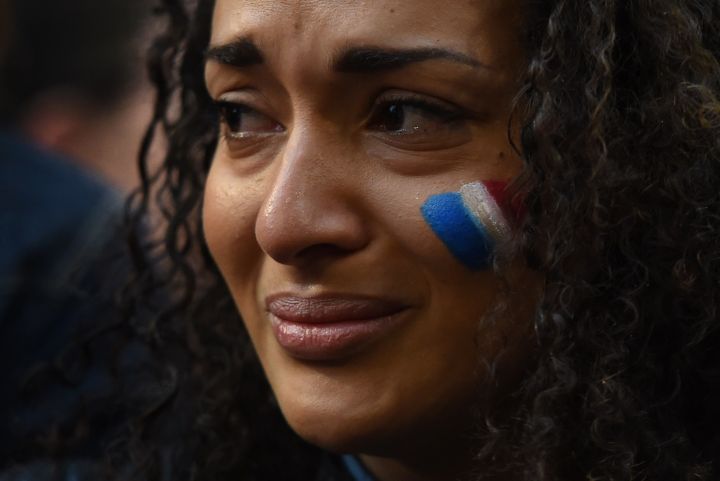 A young woman cries at a vigil held by a local French community in Sydney.
