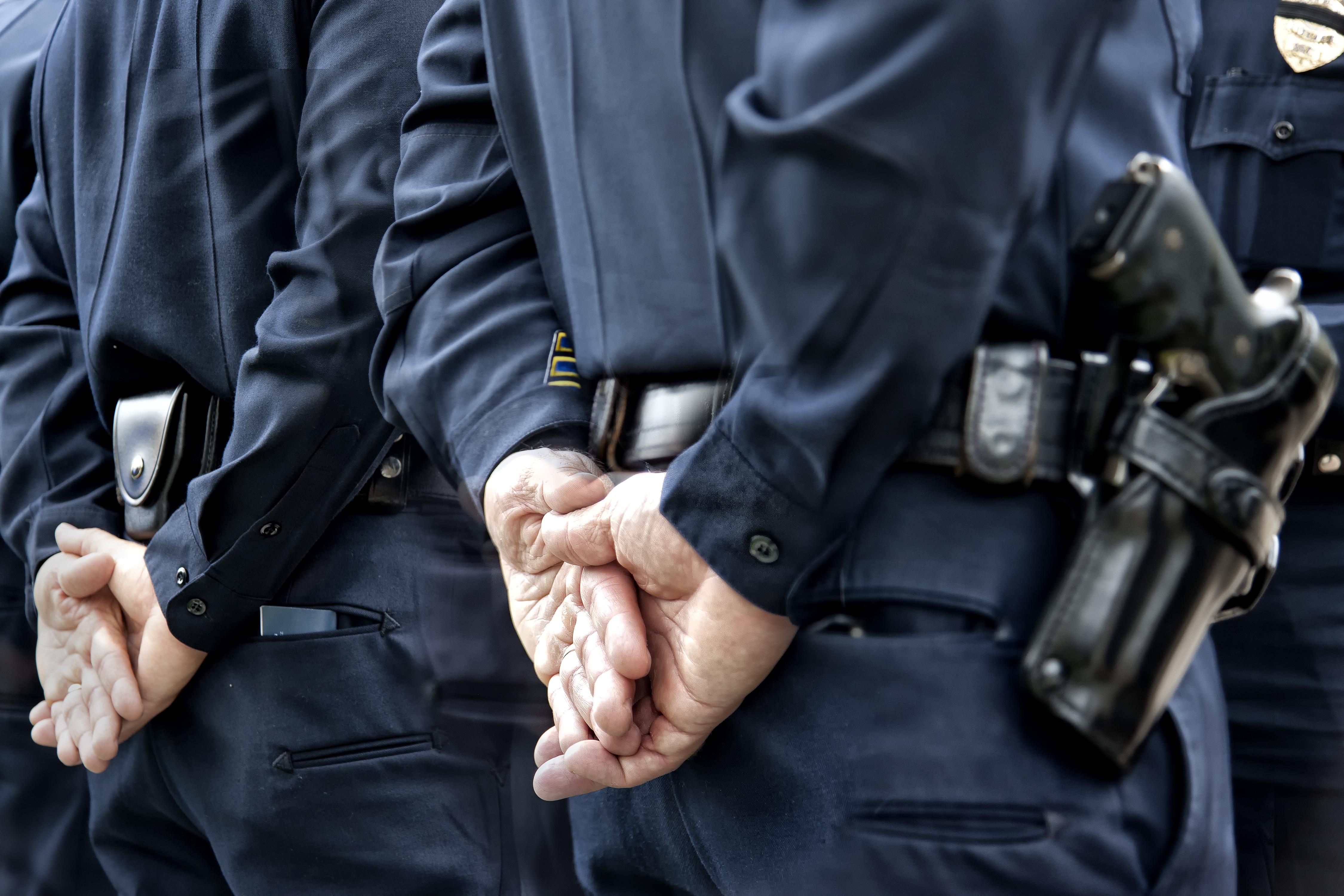 Officers standing with hands behind