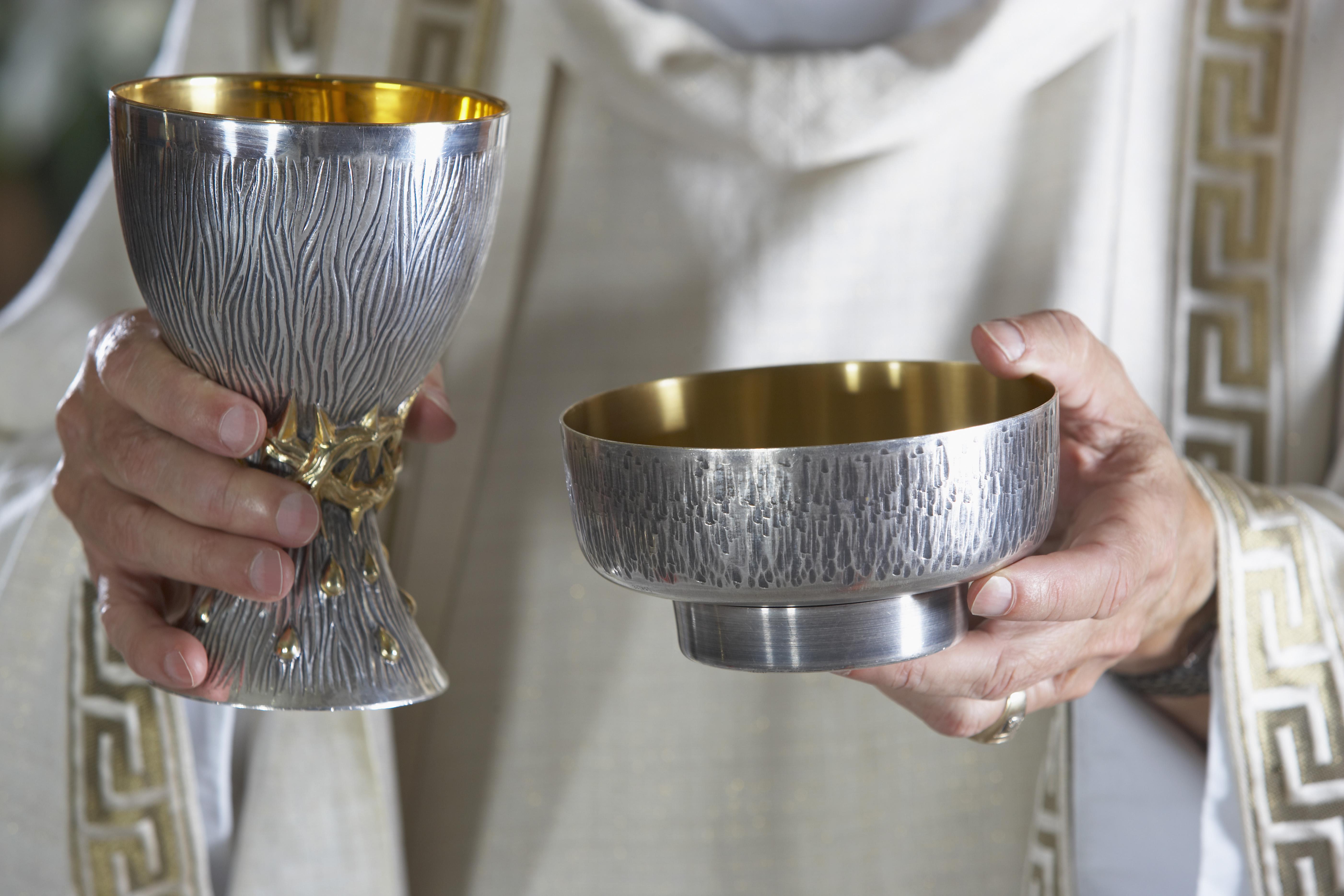 Priest holding goblet and communion bowl