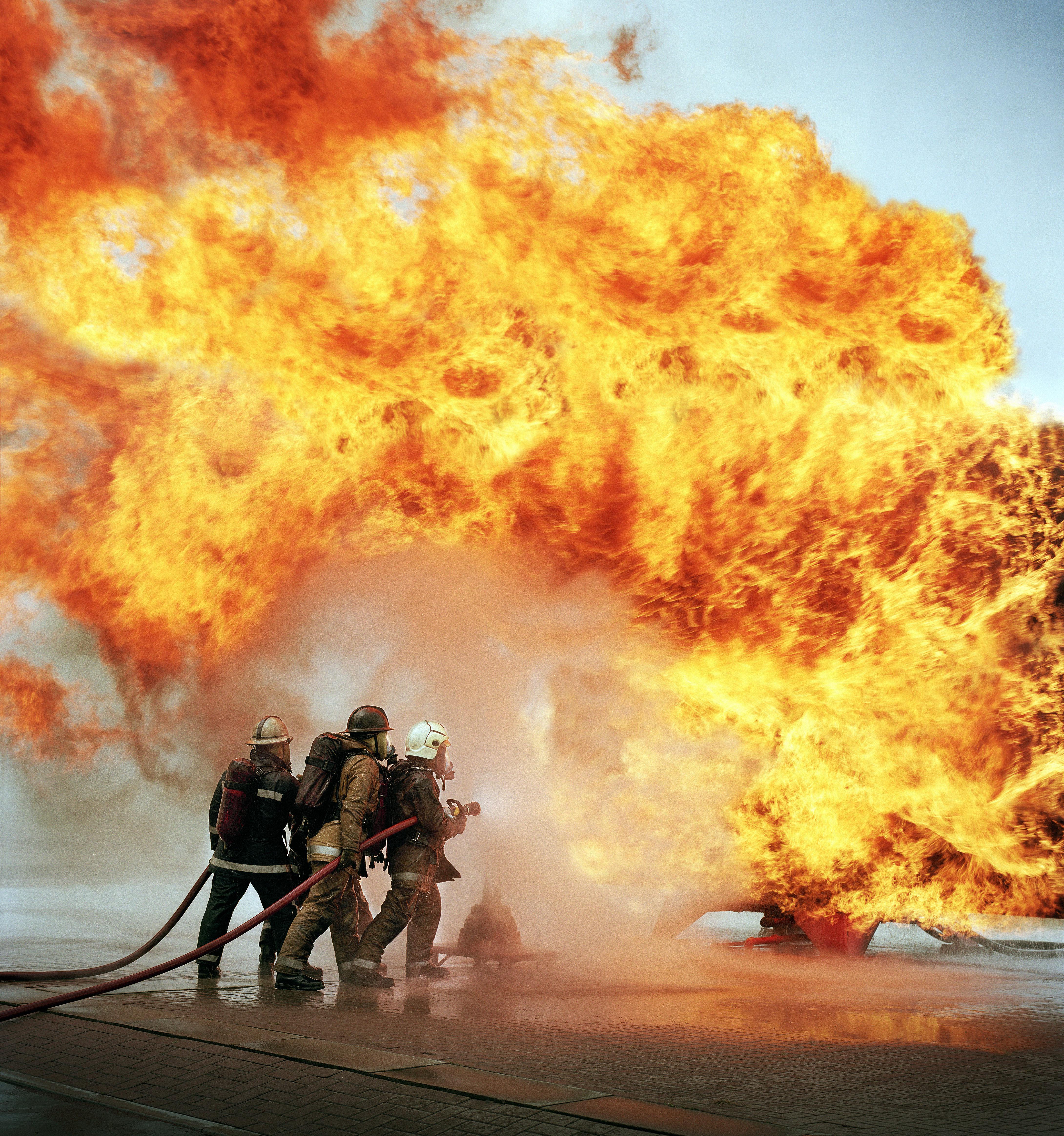 Firemen with hose fighting firewall