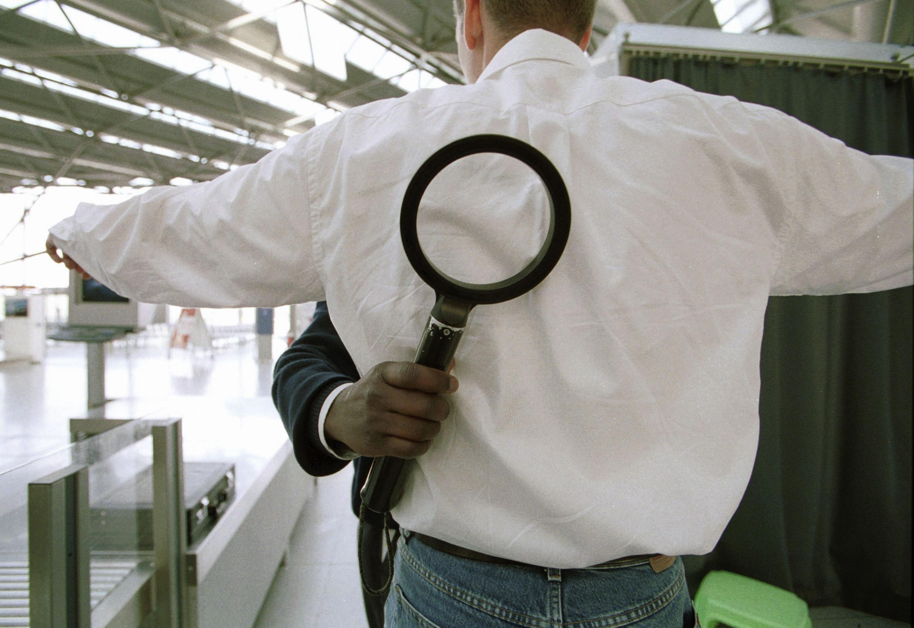 Security check at the airport Cologne / Bonn, Check of a passenger with a metal detector.