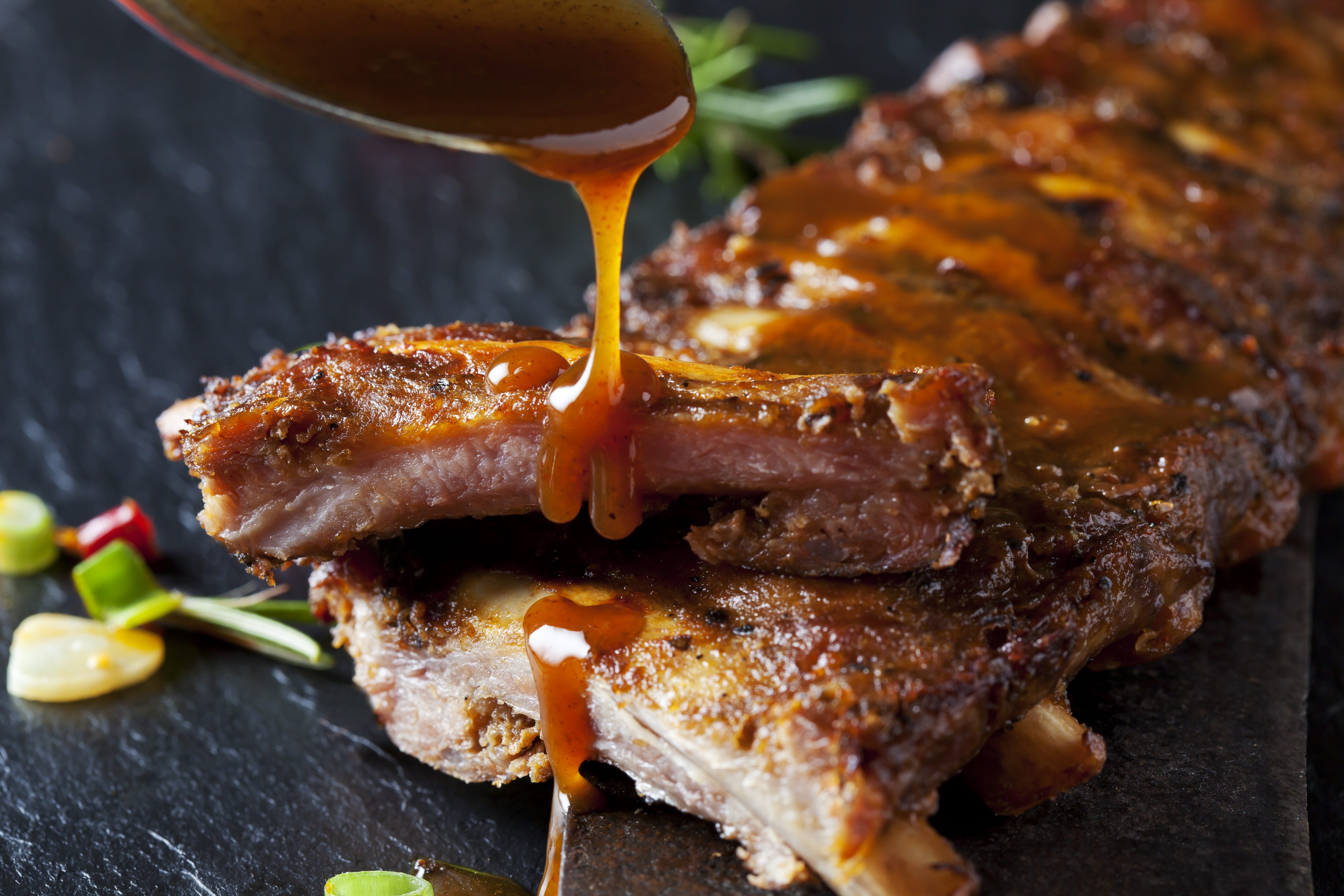 Barbecue sauce dripping on marinated and grilled spare ribs
