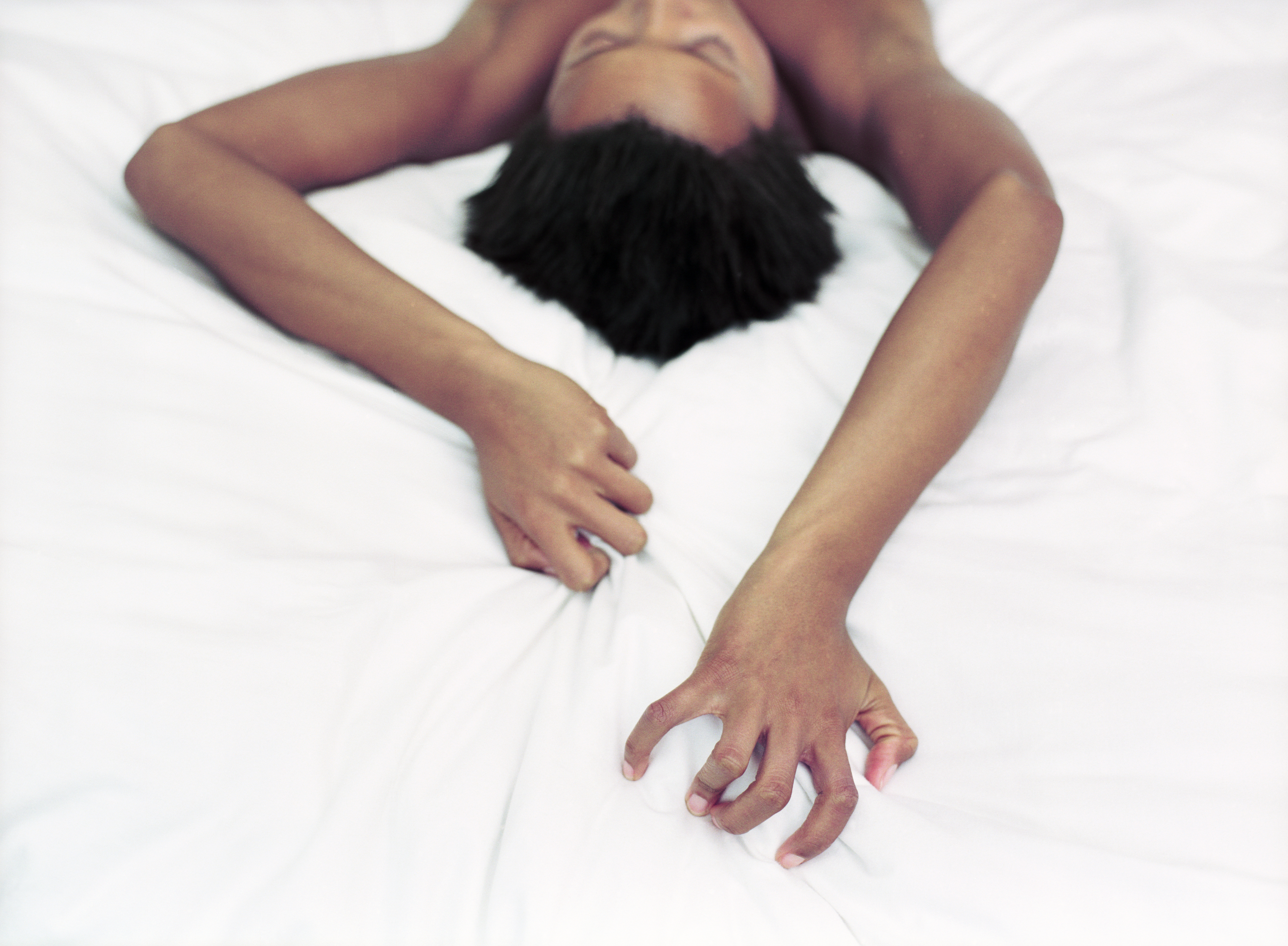 Woman Gripping Sheets During Lovemaking