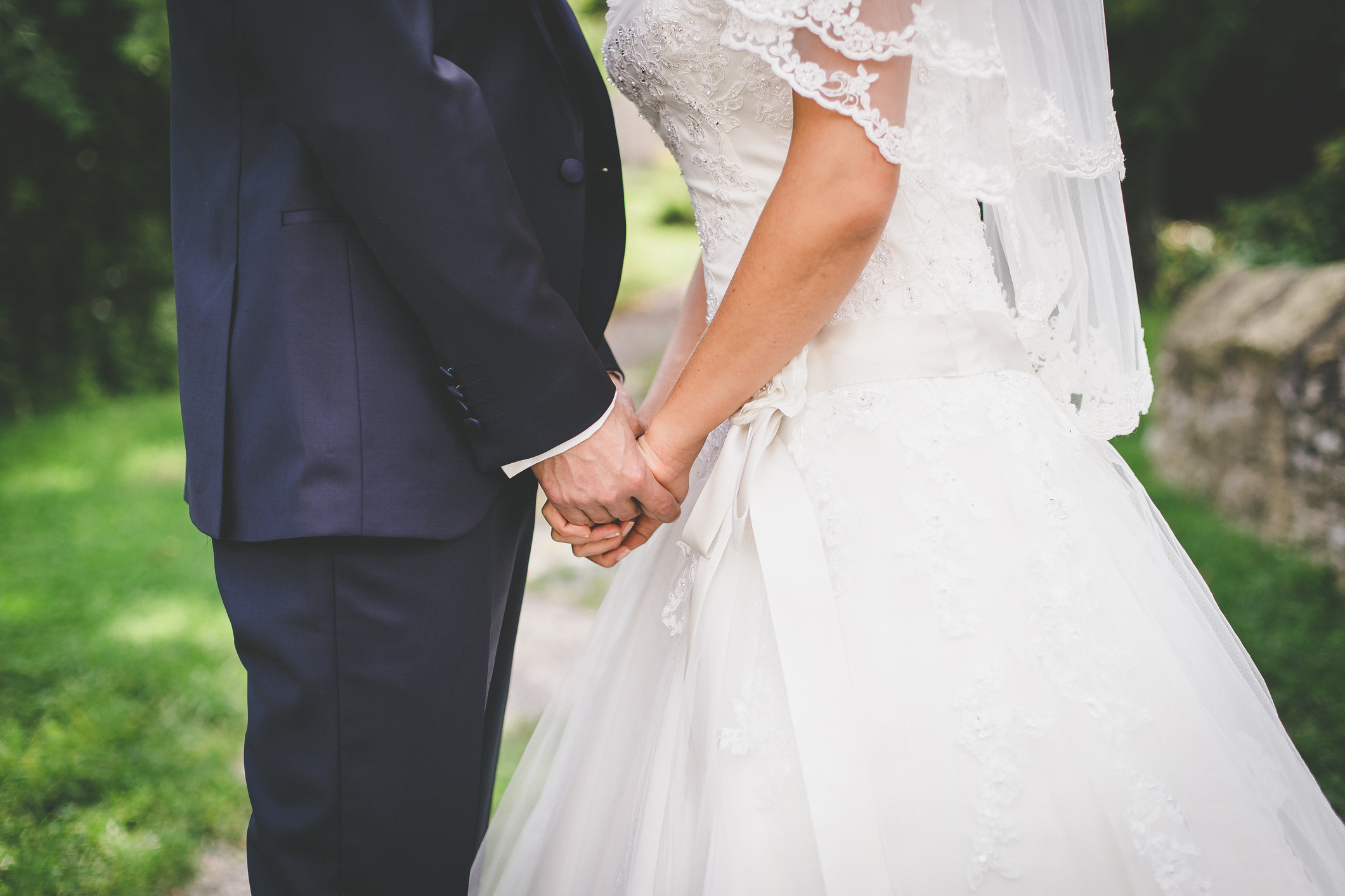 Midsection Of Couple Holding Hands At Wedding