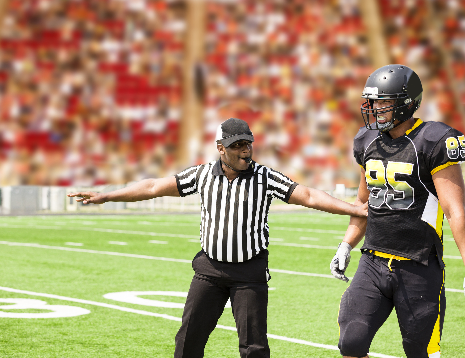 American football referee signals a play during the game. Player.