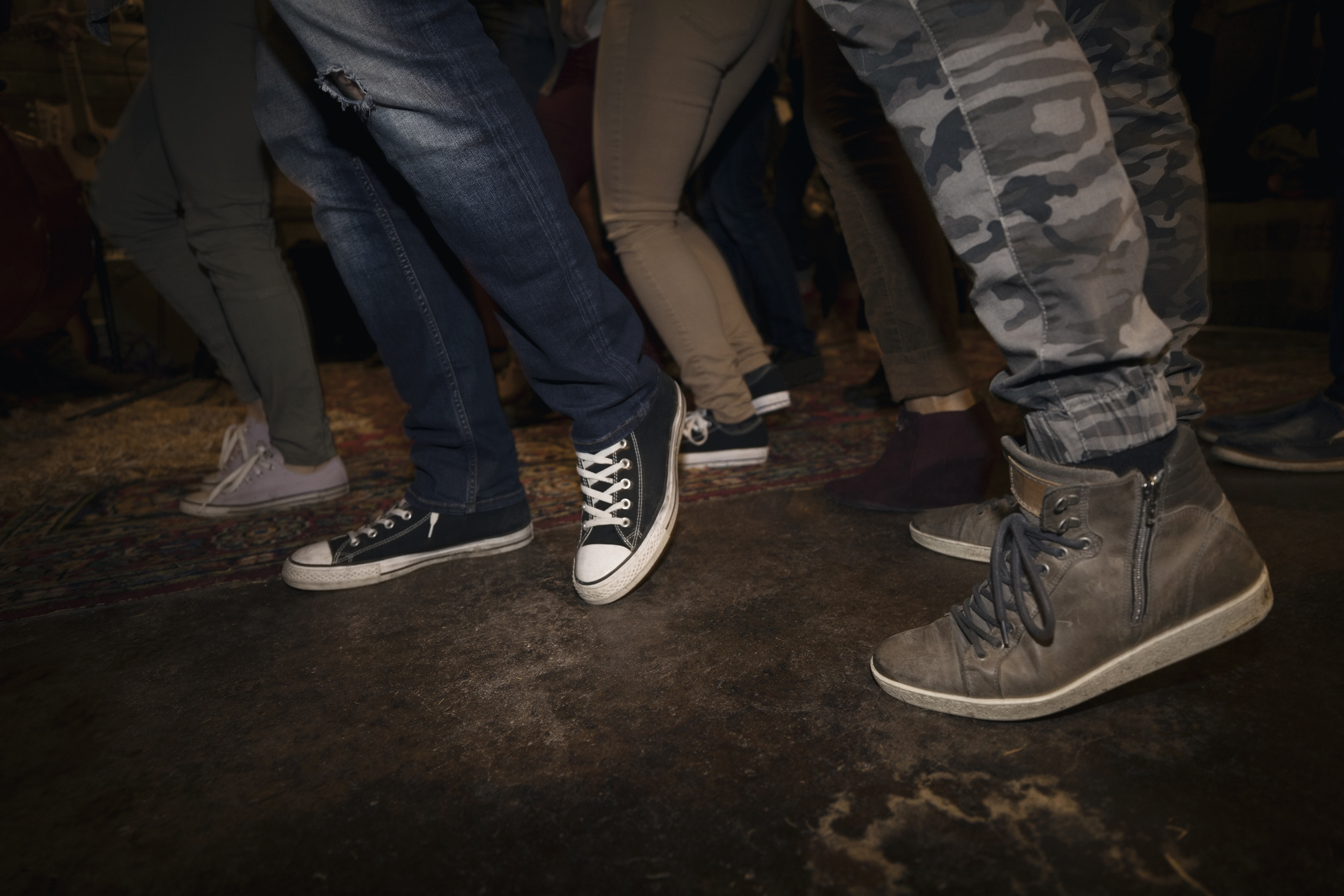 Legs of young friends dancing at party