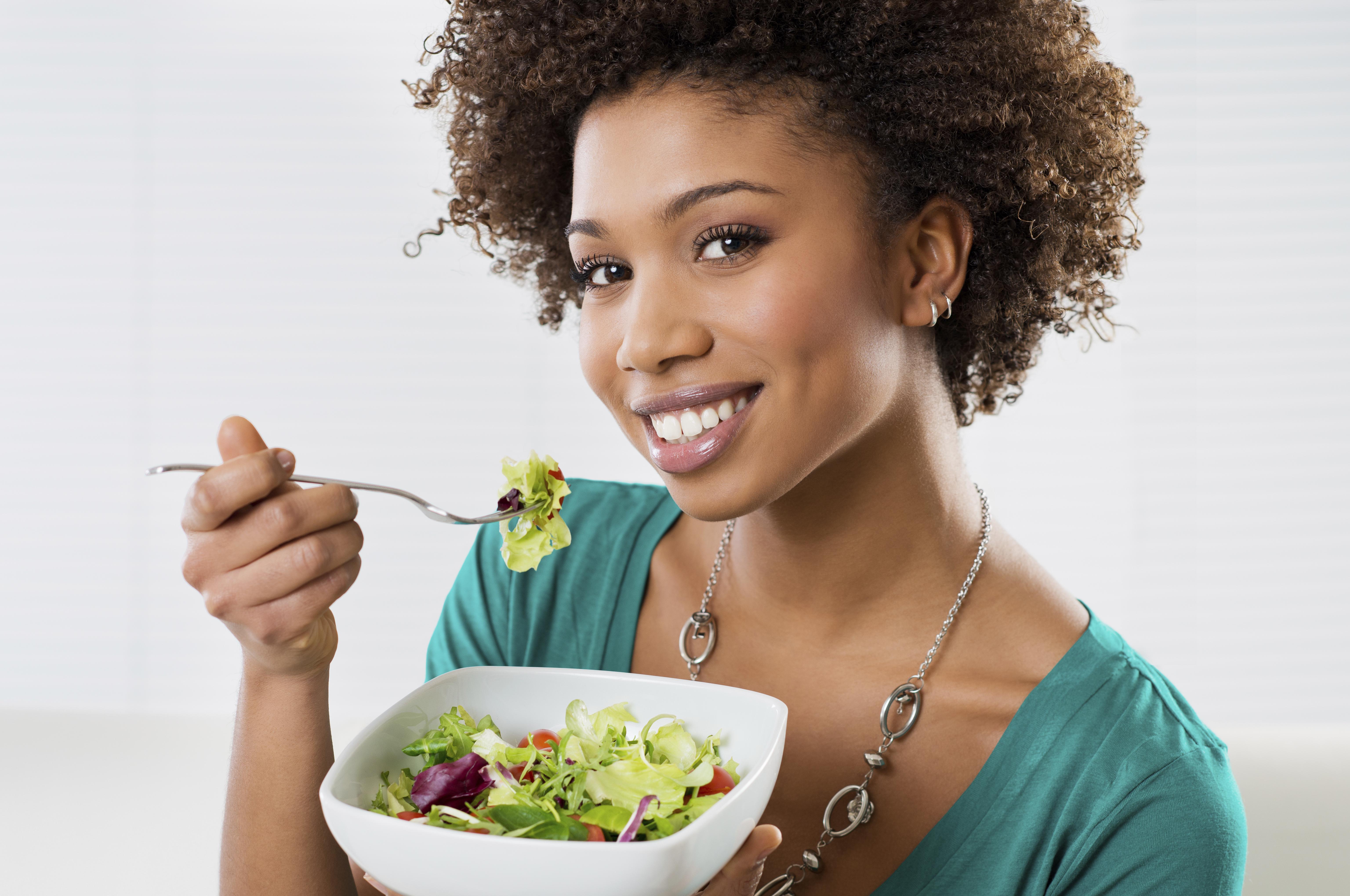 Close-up Of Beautiful African American Woman Eating Salad At Home