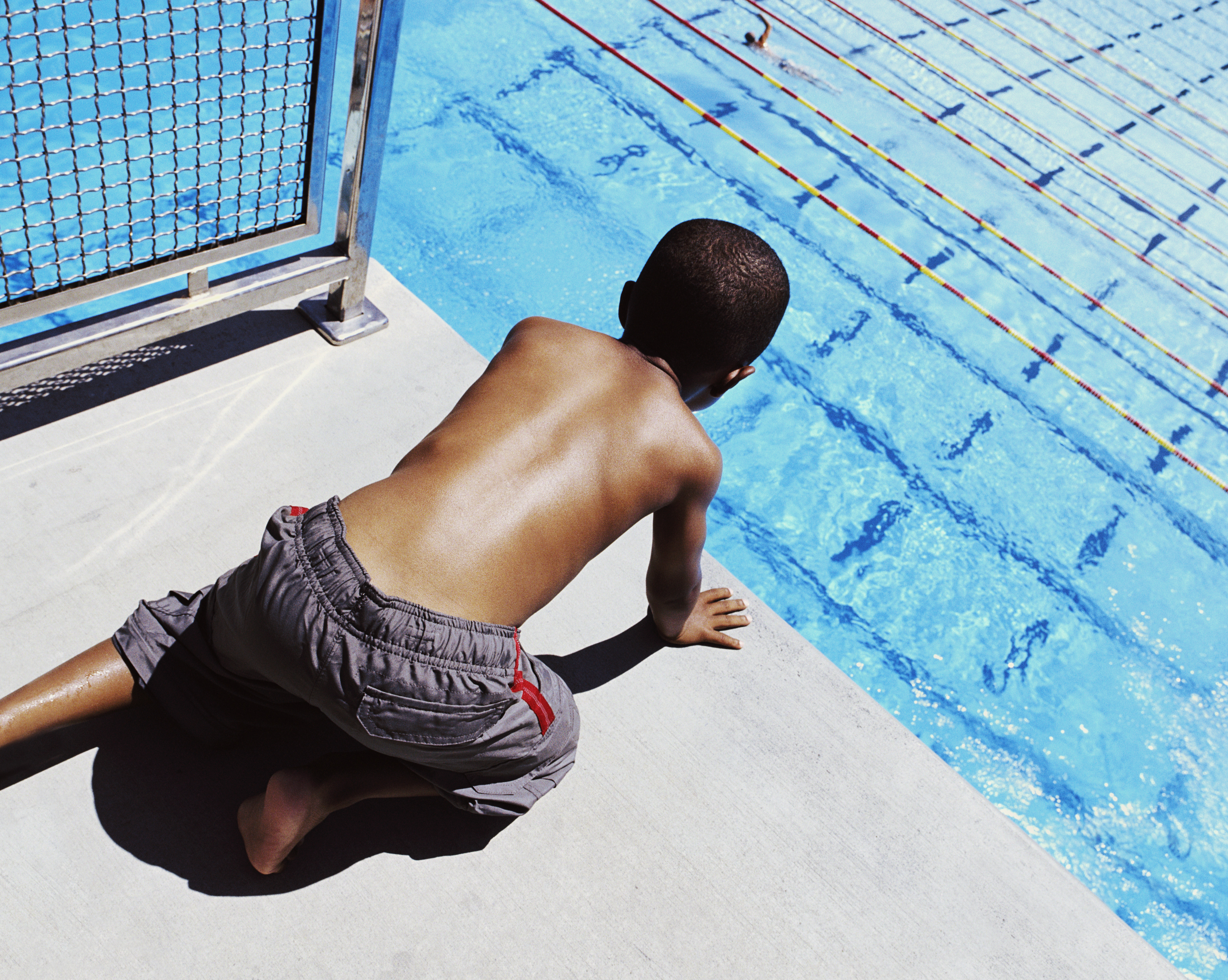 Boy (5-7) looking over diving platform, elevated view