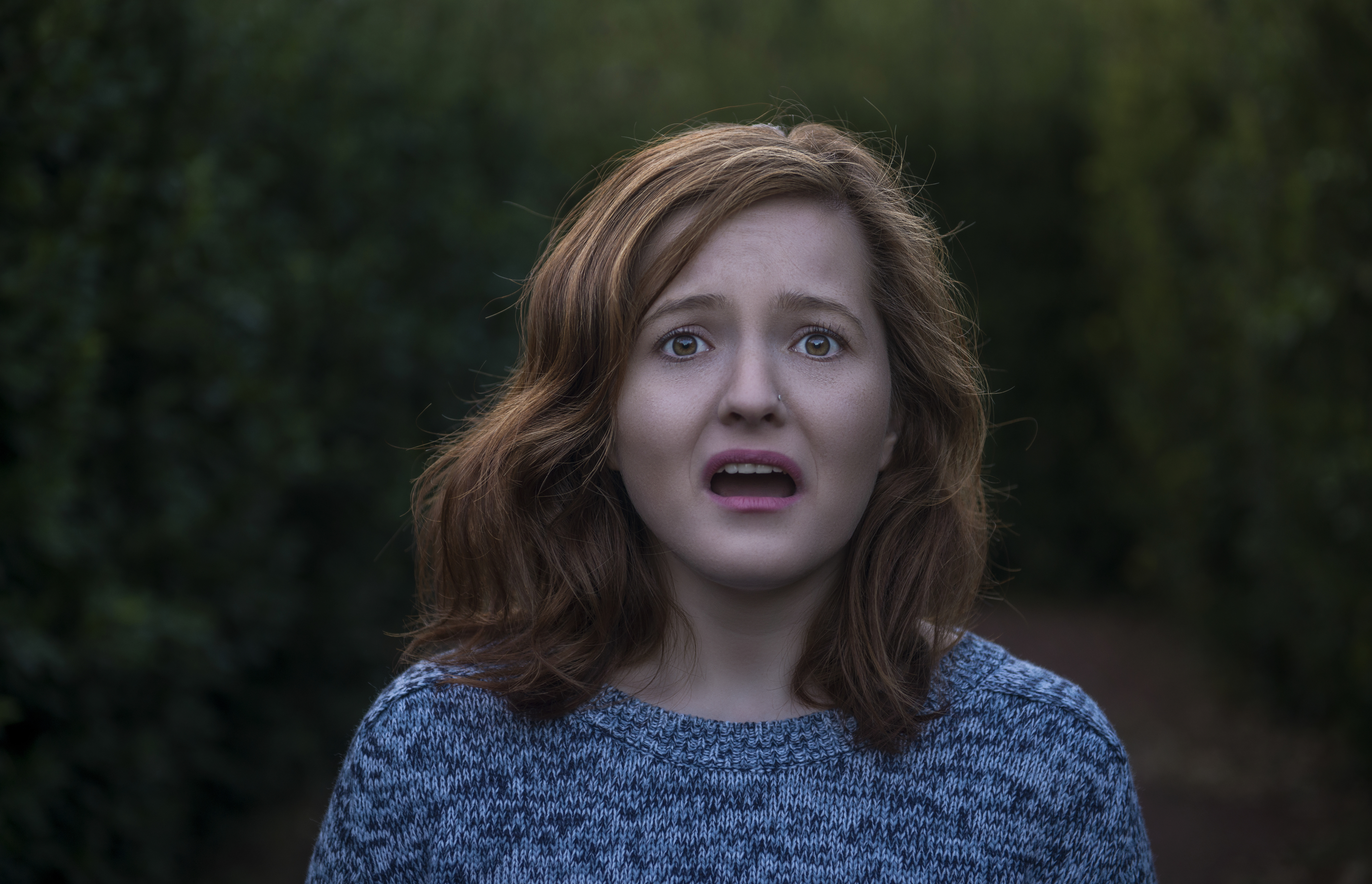 Portrait of shocked young woman looking at camera with negative facial expression
