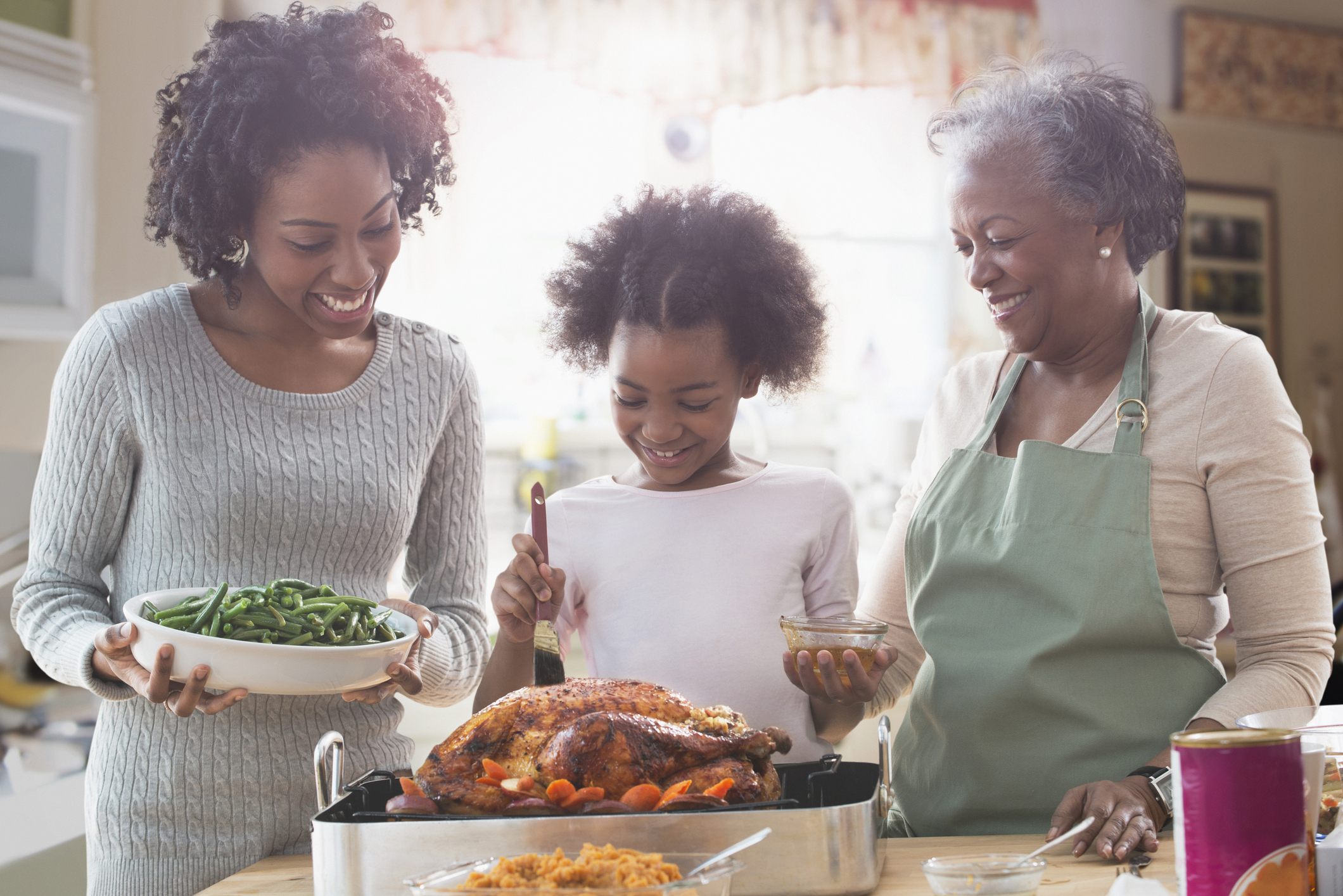 Three generations of women cooking together in kitchen