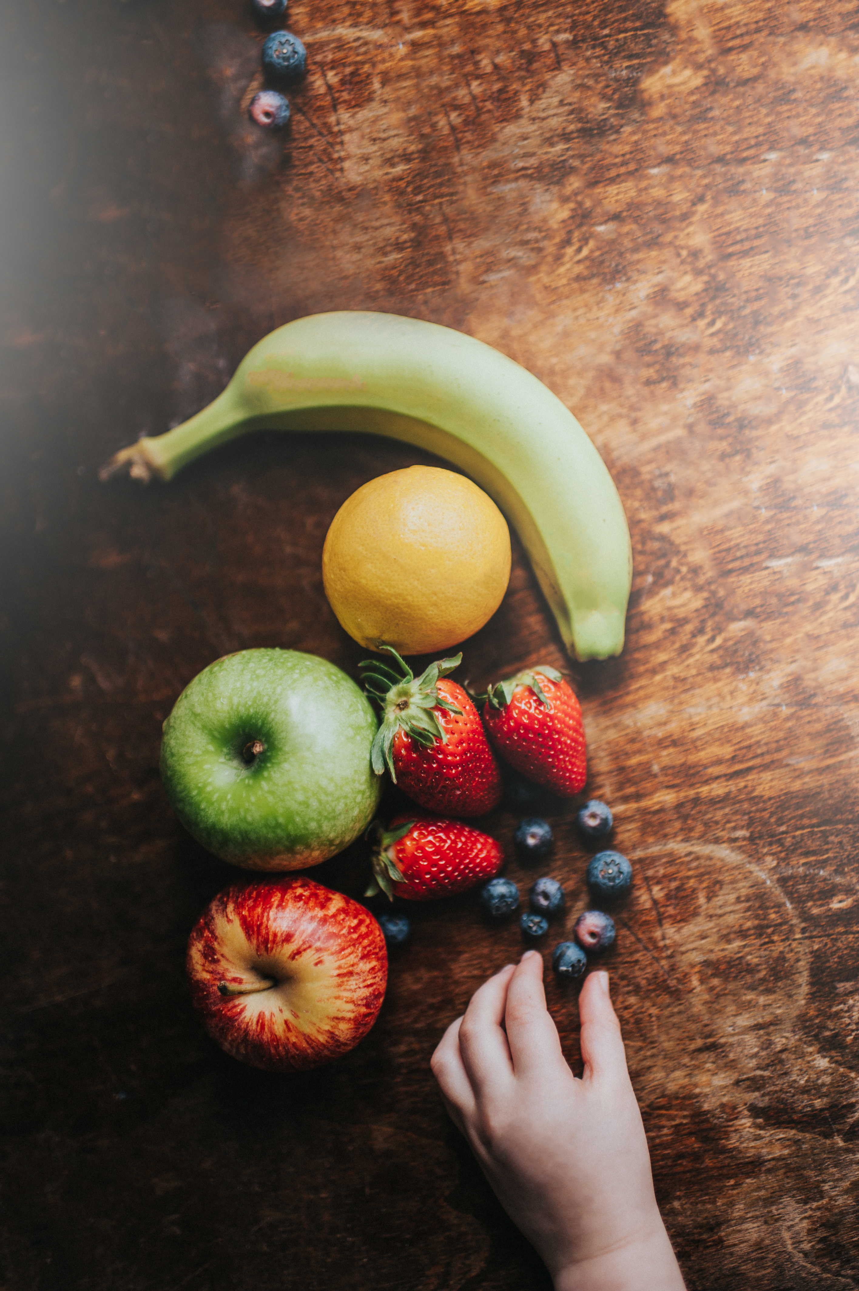 Childs hand reaching for a blueberry