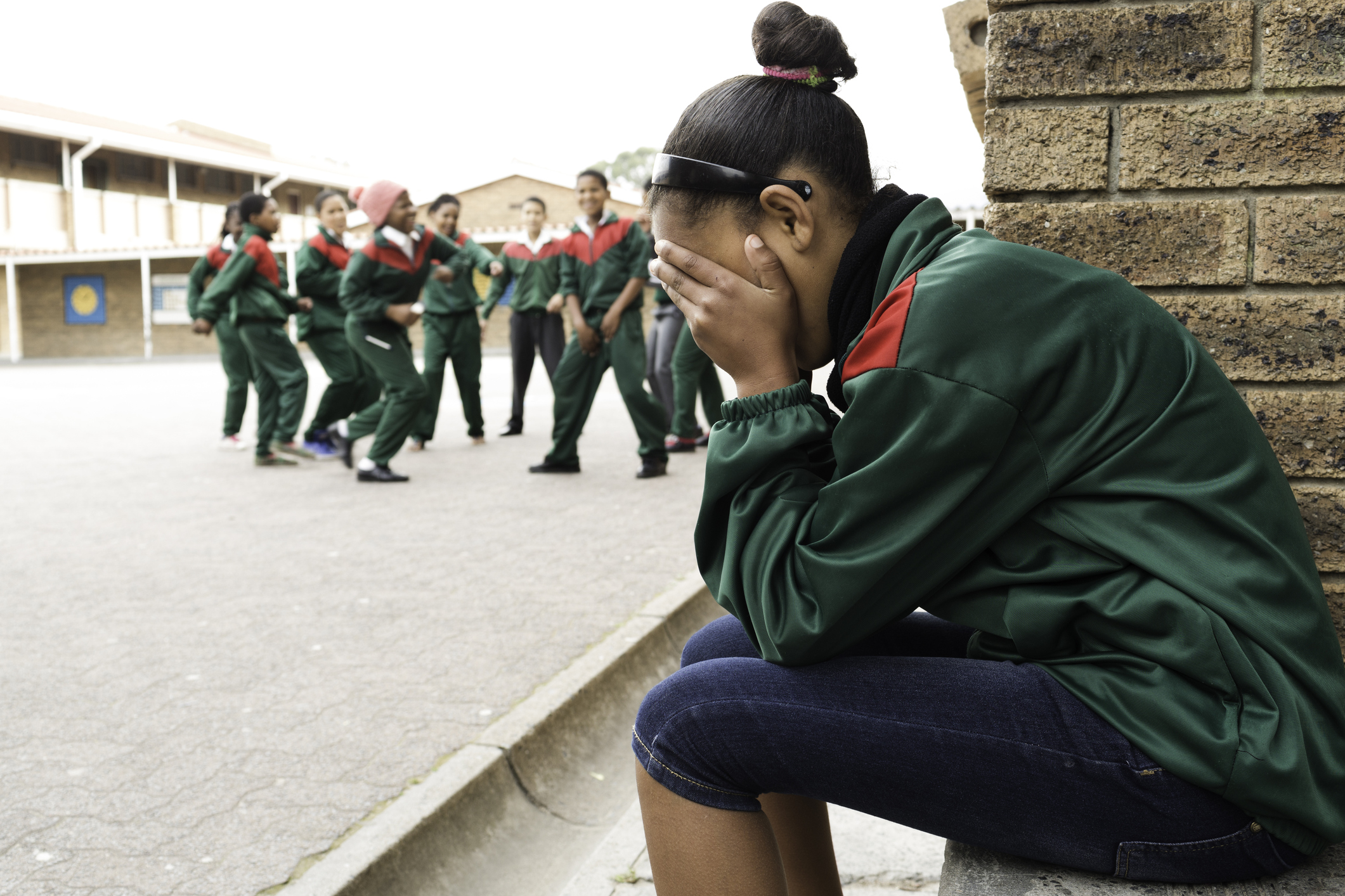 School girl cries as others laugh