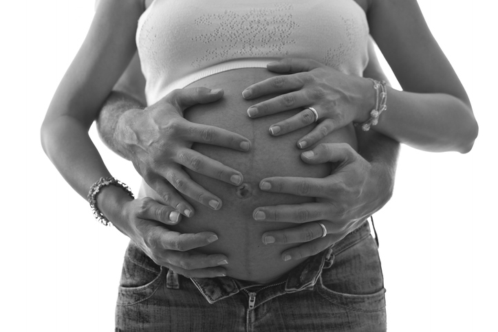 Cropped Hands Of Man Touching Pregnant Belly Against White Background