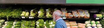 Man shops for leafy greens in grocery store