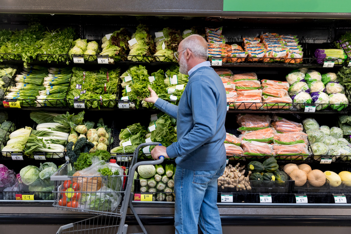 Man shops for leafy greens in grocery store