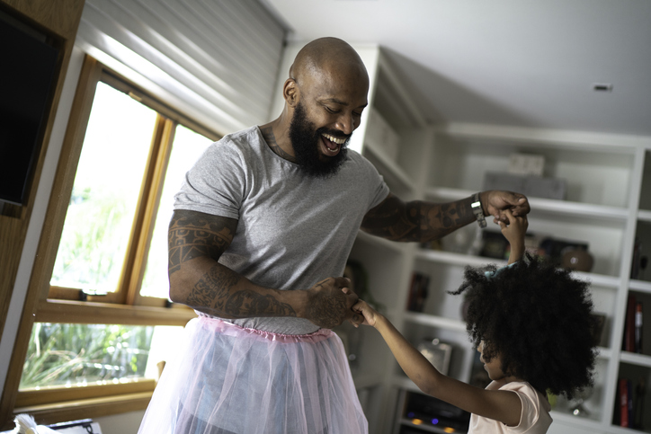 Funny father with tutu skirts dancing like ballerinas