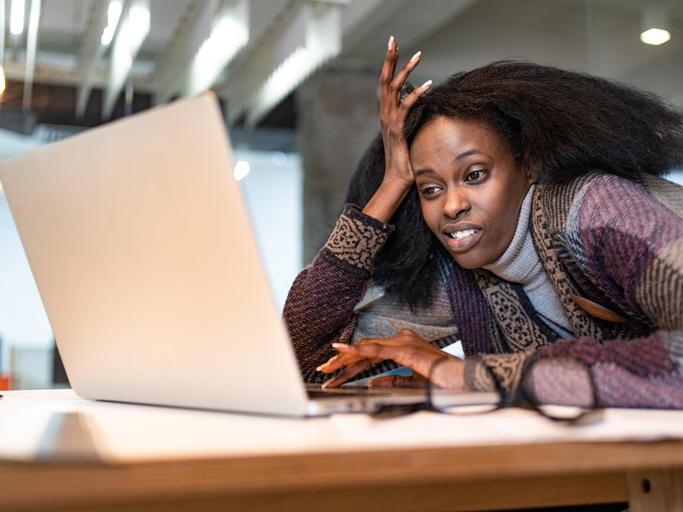 Bored black businesswoman using laptop in the office.