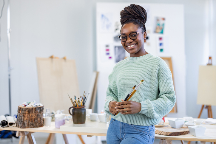 Young female artist is in her painting studio
