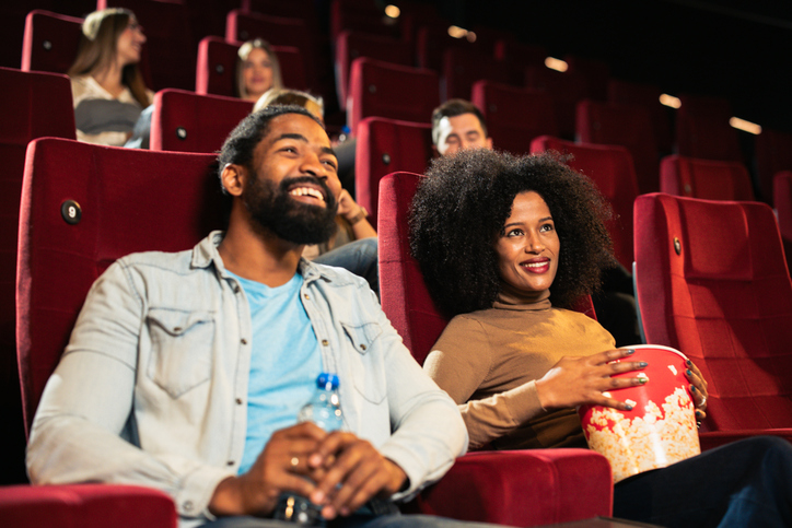 Couple laughing while watching a movie at the cinema