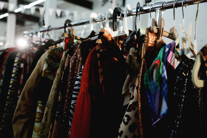 Garage Sale With Thrifting And Second Hand Silk Dresses And Blouses On Clothing Racks. Full Frame, Ambient Light