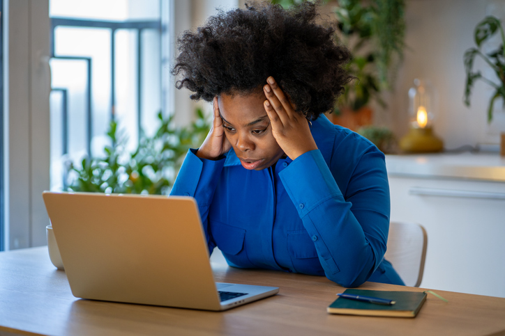Overwhelmed black woman with mental fatigue feels stress demotivation, lack of focus looks at laptop